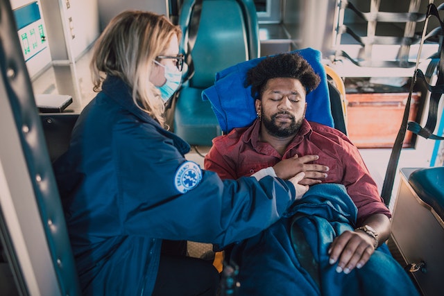 injured man and paramedic in ambulance